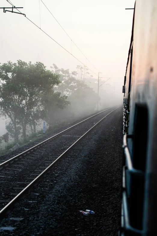 a train is riding on a track in the fog