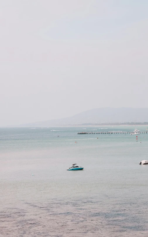 boats floating in the ocean off of the coast