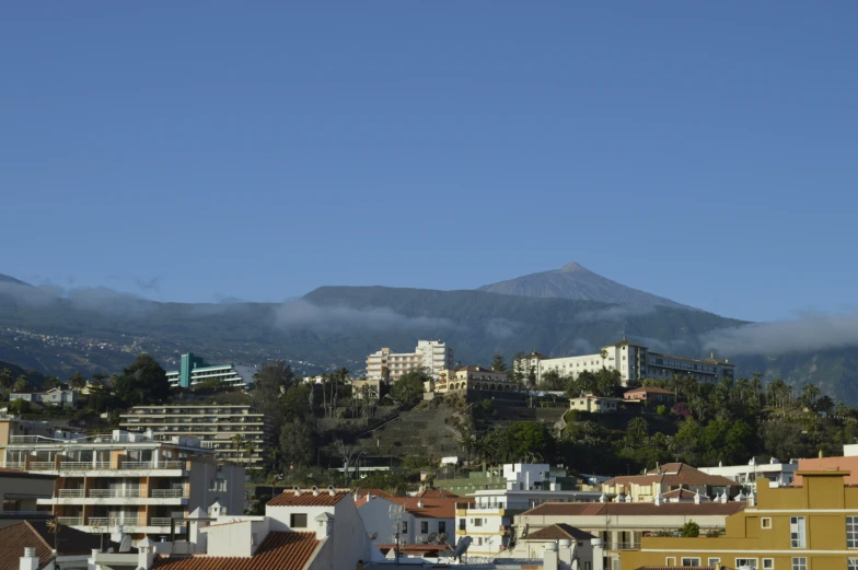 a view of the city below a foggy mountain