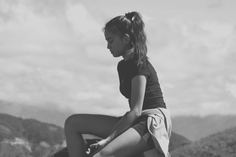 a black and white image of a girl with shorts on a mountain