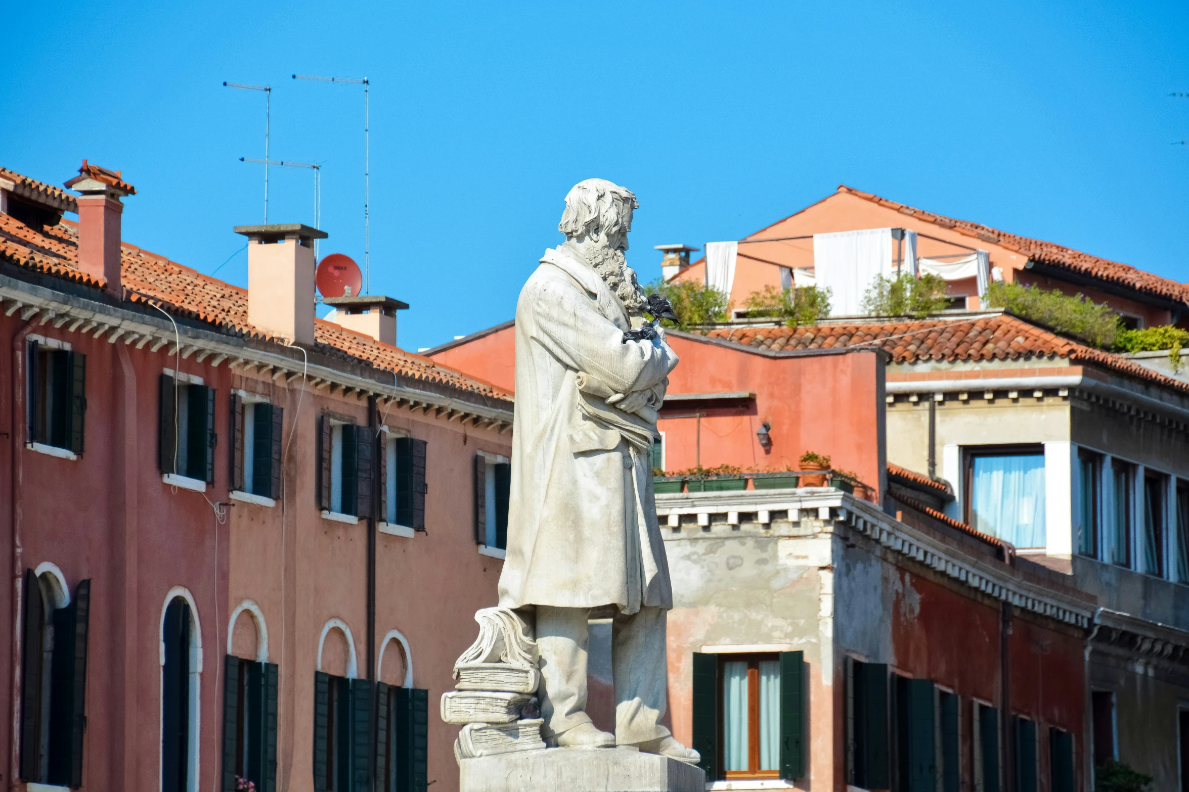 a statue of an old man next to some buildings