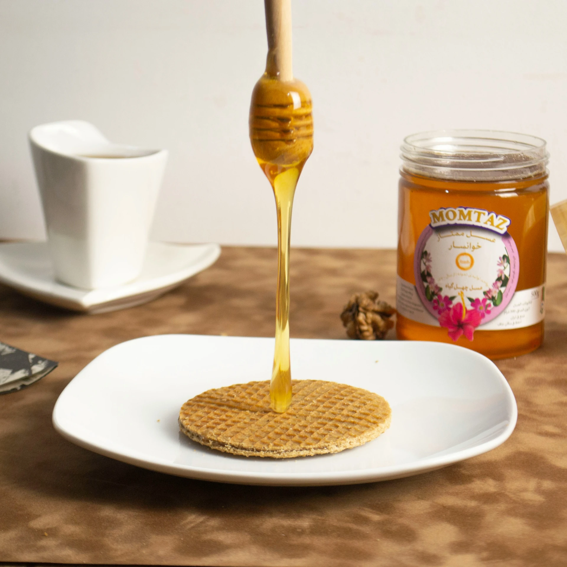 honey being poured on to a plate with food on a table