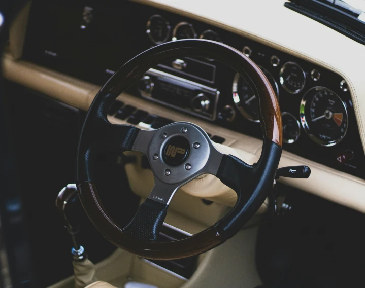 a view inside of an old car, of the steering wheel, and dashboard