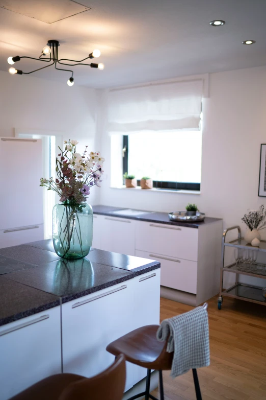 vase with flowers on a counter with brown stools