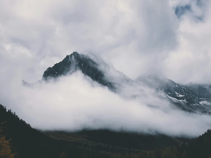 a mountain in the distance has some thick clouds