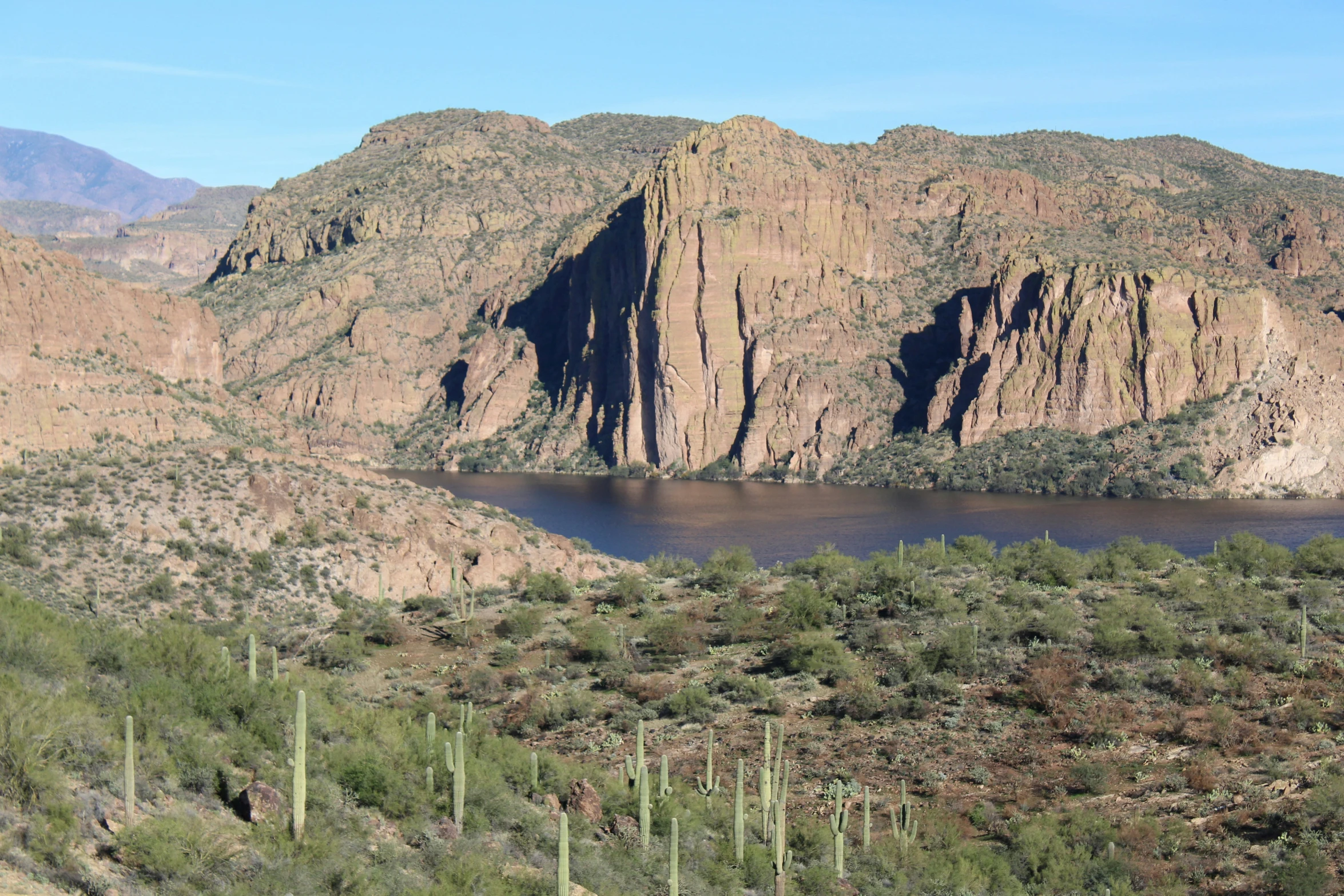 a large body of water surrounded by mountains and vegetation