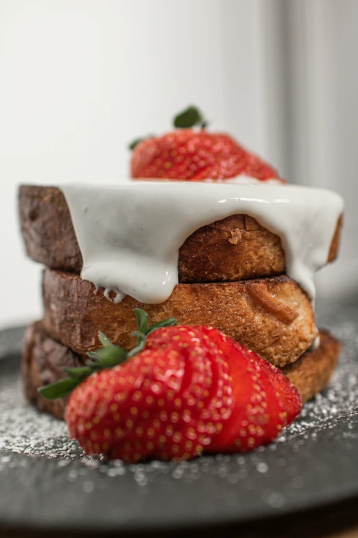 some strawberries that are laying down on a piece of bread