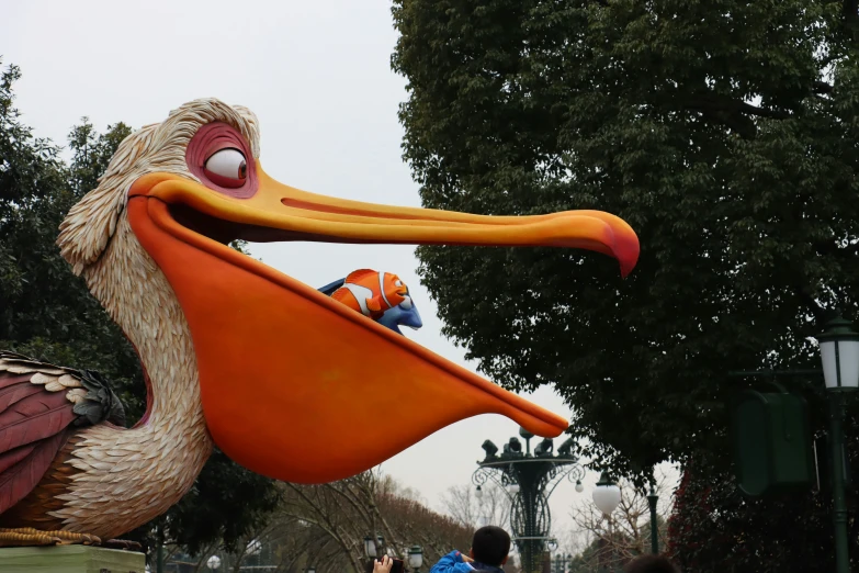 a bird float in a park that has people watching it