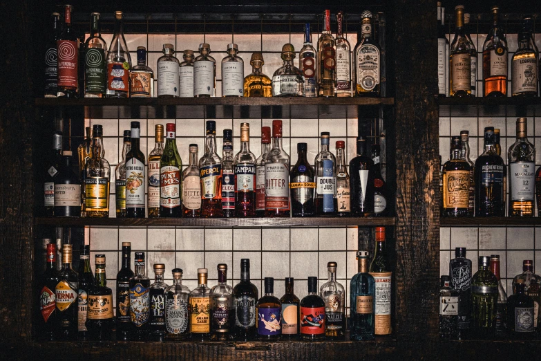 bottles of various types are on the shelves of a bar