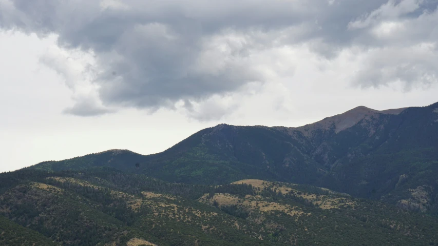 several different mountains in the distance with a small bird sitting on top