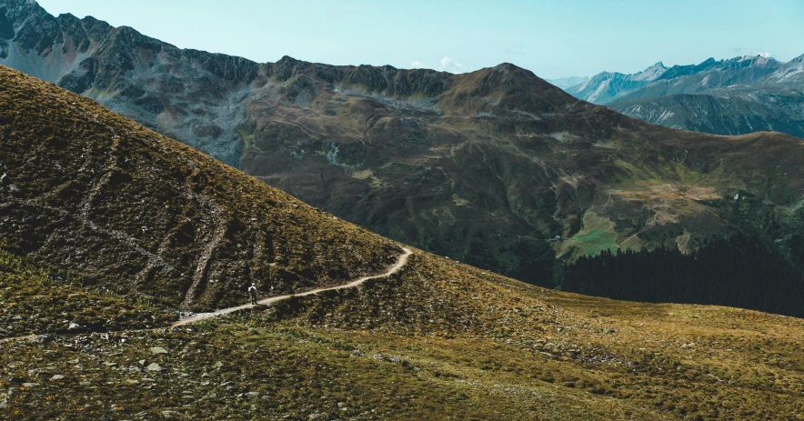 a trail going across a large grassy hill