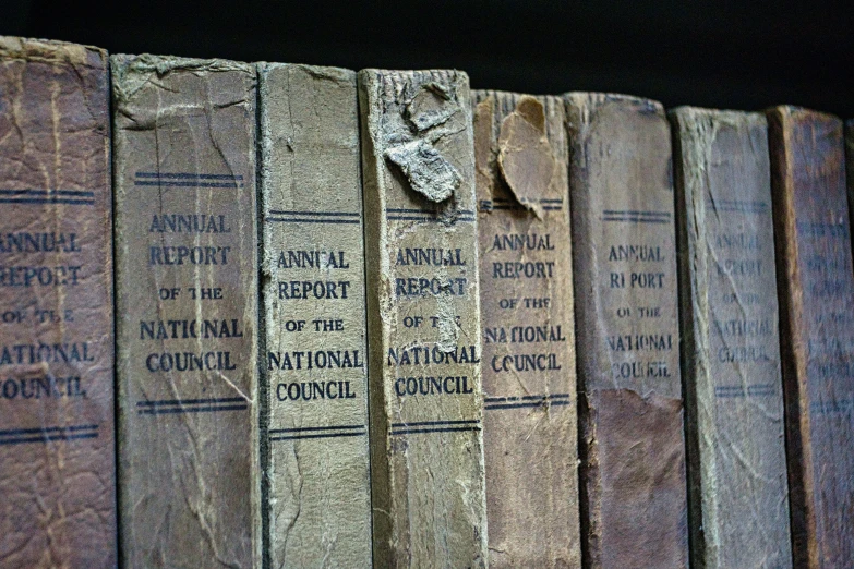 rows of old books sit on top of each other