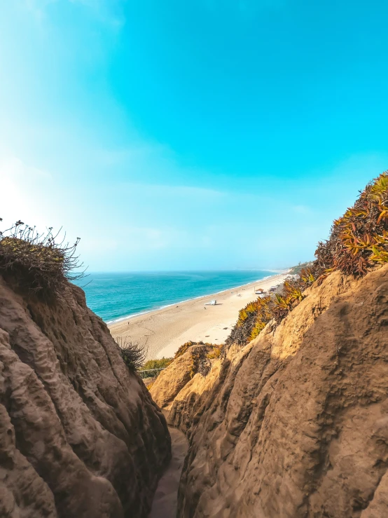 the pathway up to a sandy beach is covered in sand