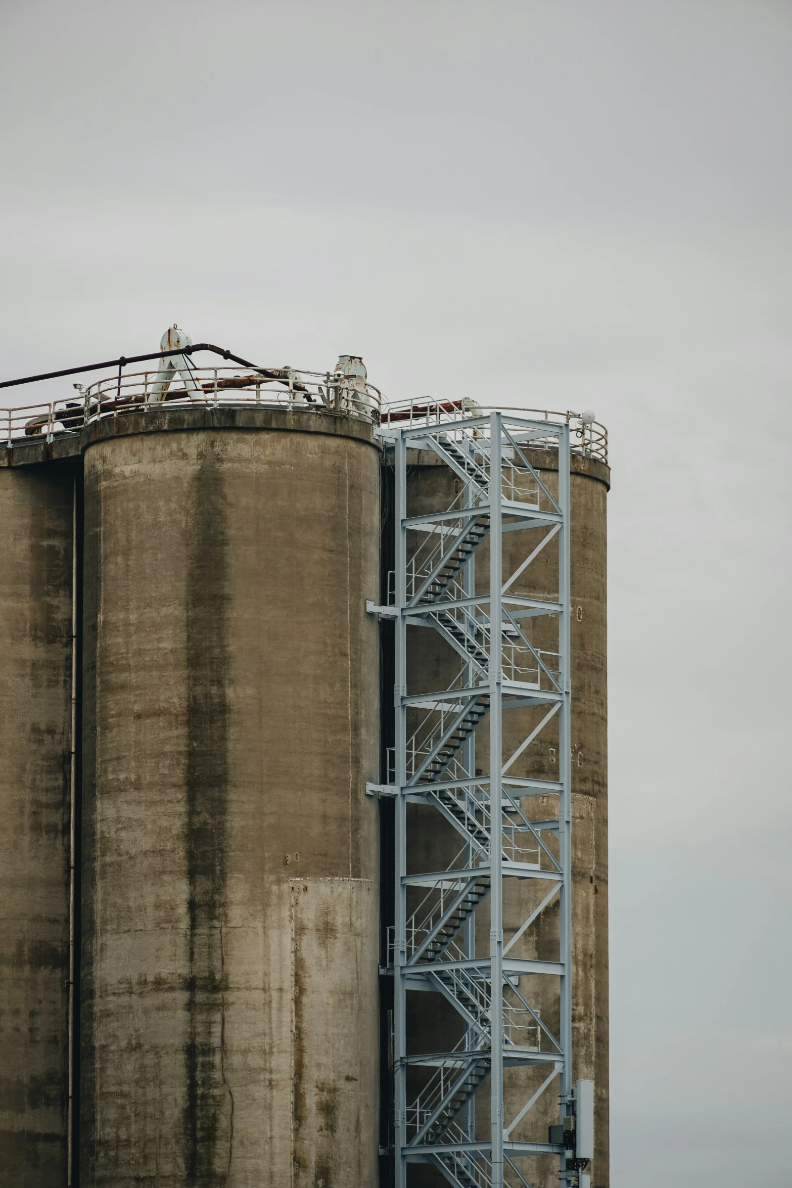 a very tall industrial building with very skinny white baloons