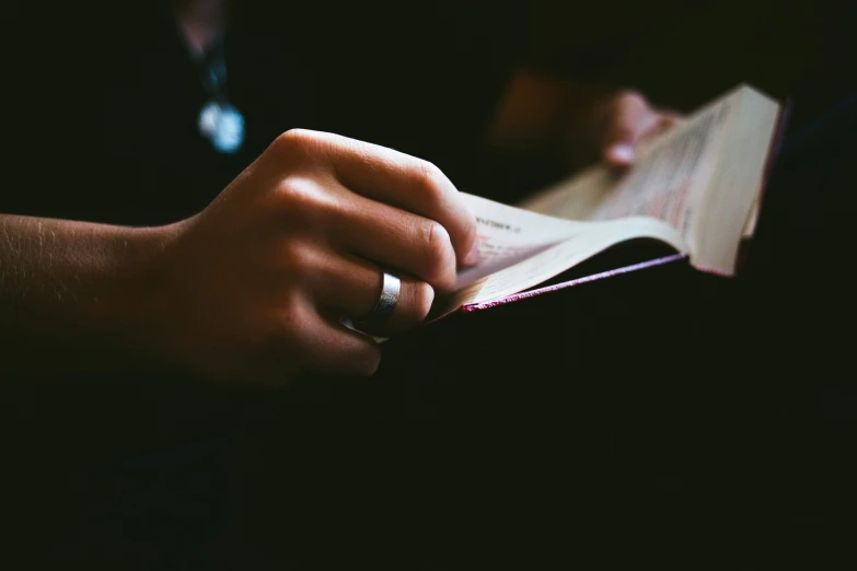 a person holding an open book and reading it