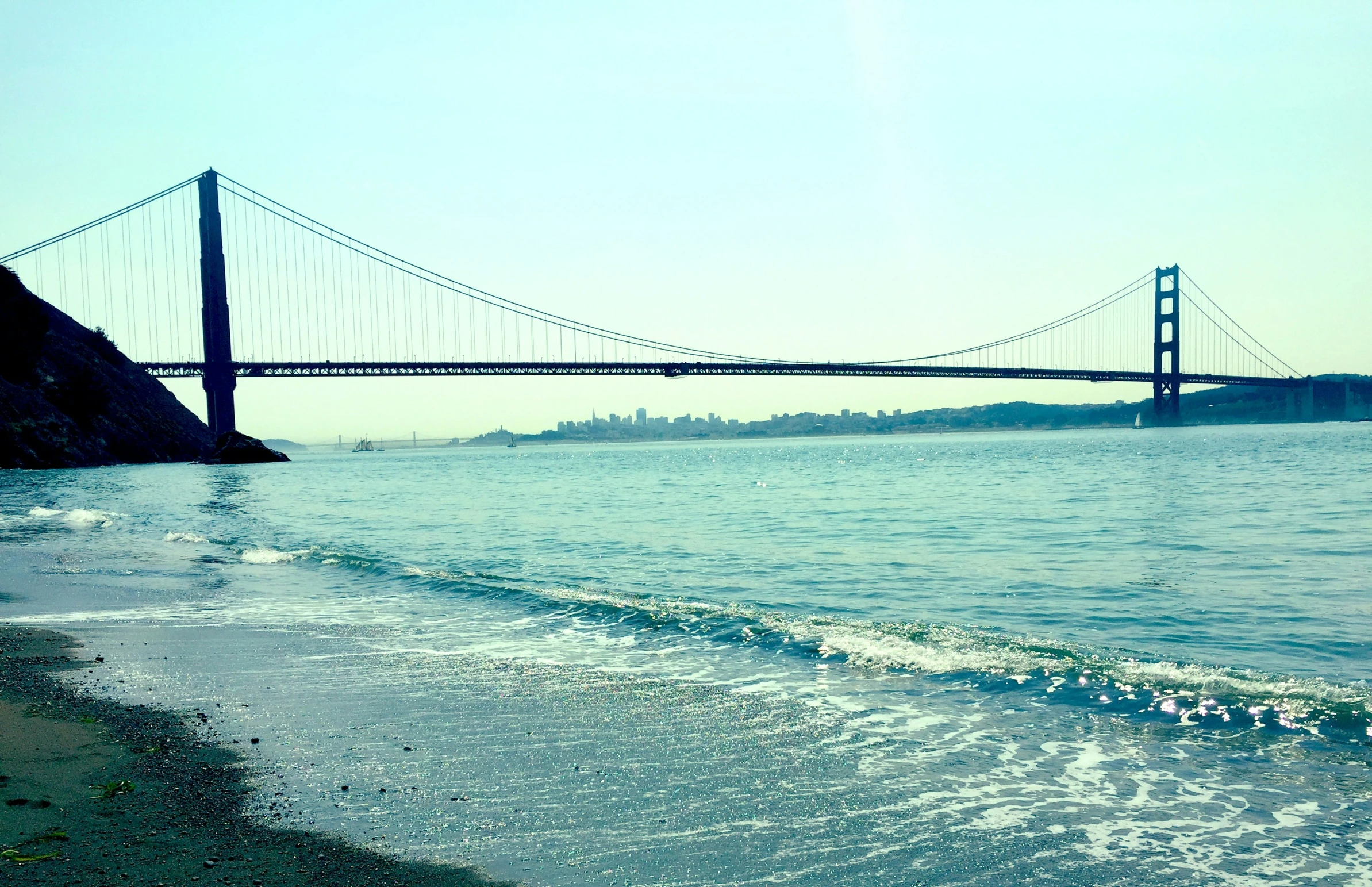 the water is gently flowing from the sandy shore