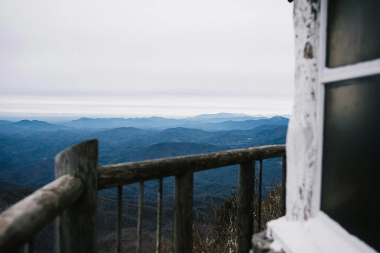 the wooden steps leading to a balcony that has a view over mountains