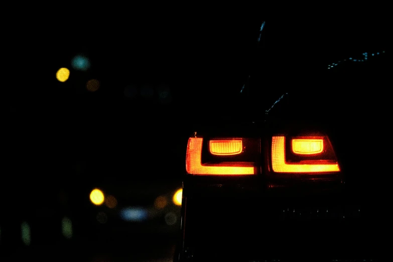 the taillights on a black vehicle at night