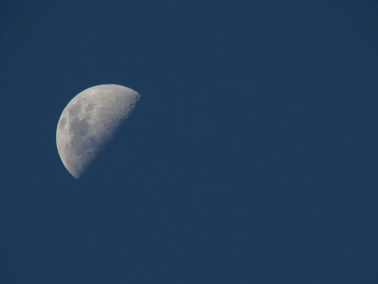 a half moon with blue sky in the background