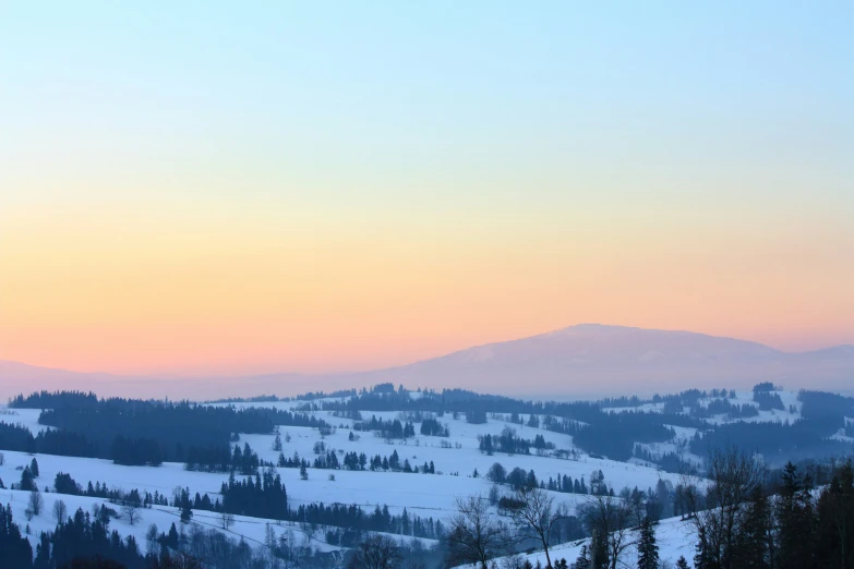 the sun is setting over a beautiful winter landscape