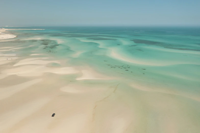 a long sandy beach on the shore with white sands