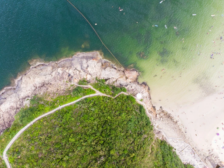 a view from the air shows a path that goes to the beach with people on it