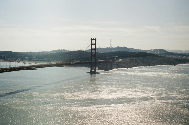 a bridge across a body of water with a mountain in the background