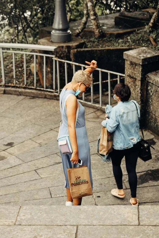 two women are standing on the street and one is showing soing