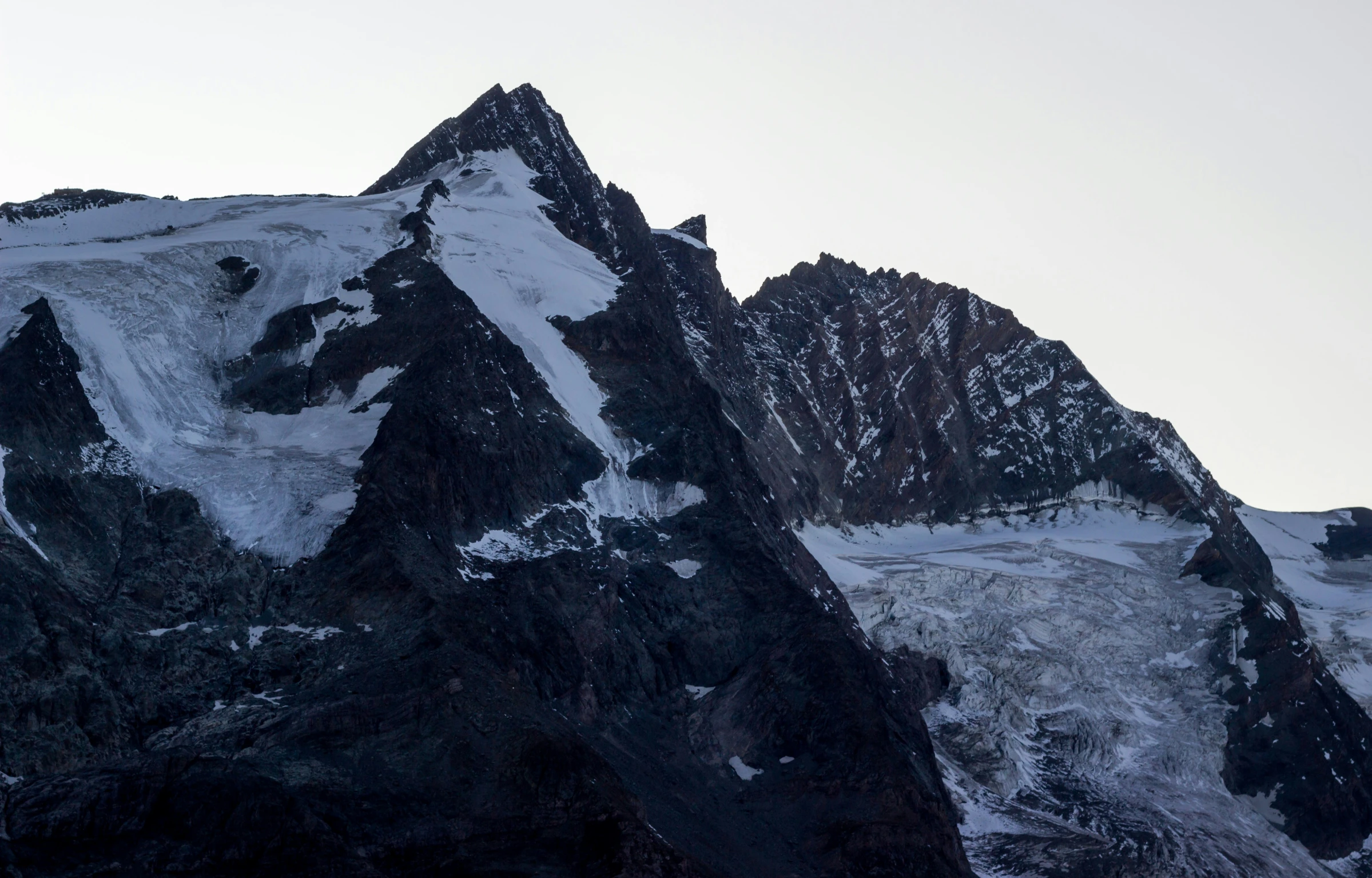 a lone bird is flying above the mountain top