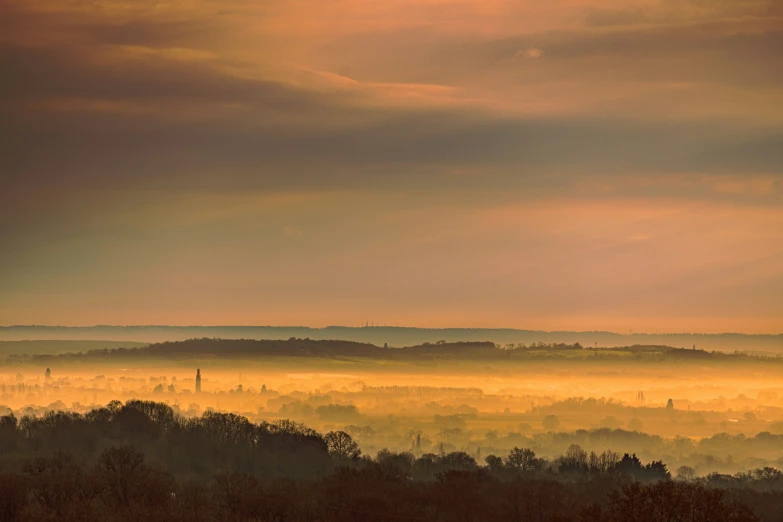 fog covers the valley below, as seen from a distance