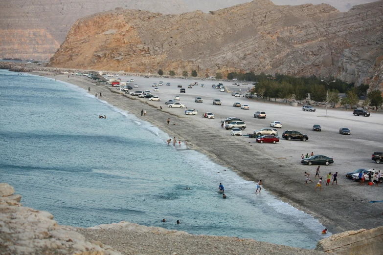 the people are playing on the beach next to the water