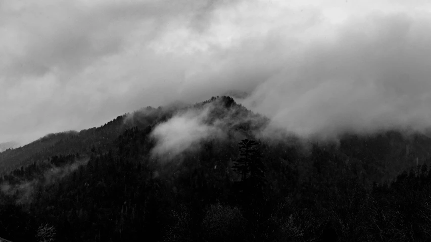 black and white po of fog rolling over mountains