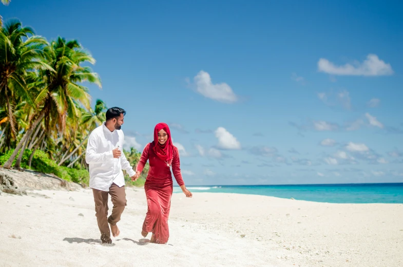 two people walking on the beach holding hands