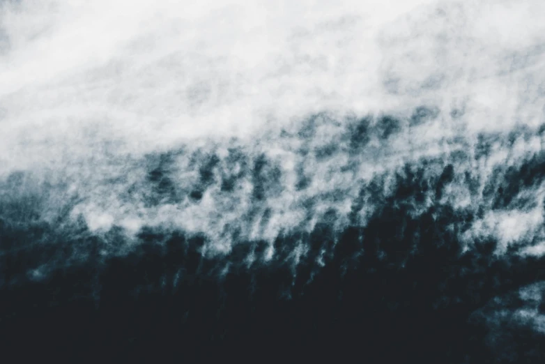 an airplane flies over the clouds over mountains