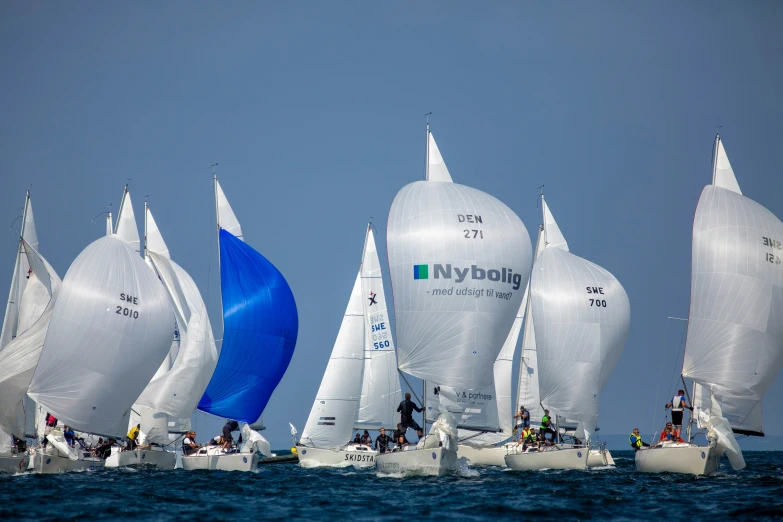 sailboats are sailing in blue waters with clear skies