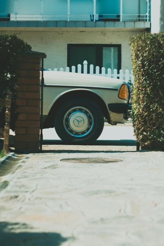 the truck is sitting by the white fence and building