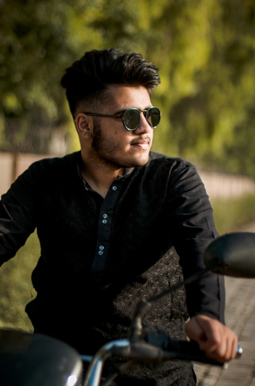 a man in shades is sitting on a motorcycle