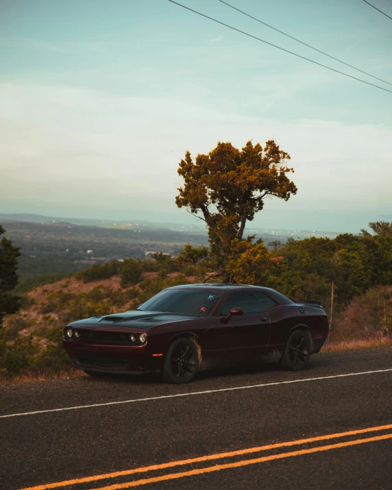 a black and red car sitting on the side of a road