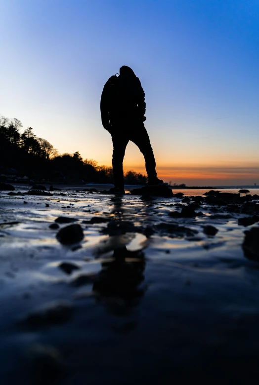 silhouette of a person who is walking on the beach