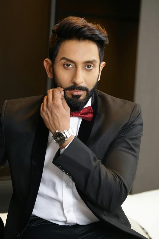 man in black suit with red bow tie looking into camera