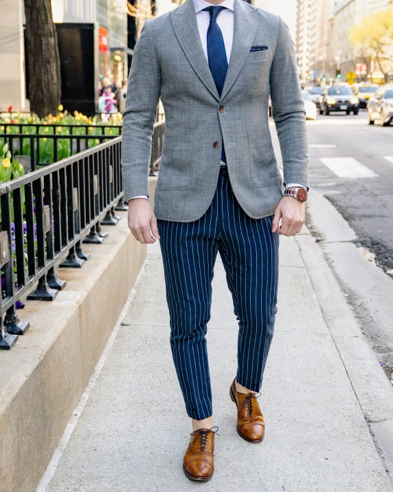 a man in a suit and tie walking down the sidewalk