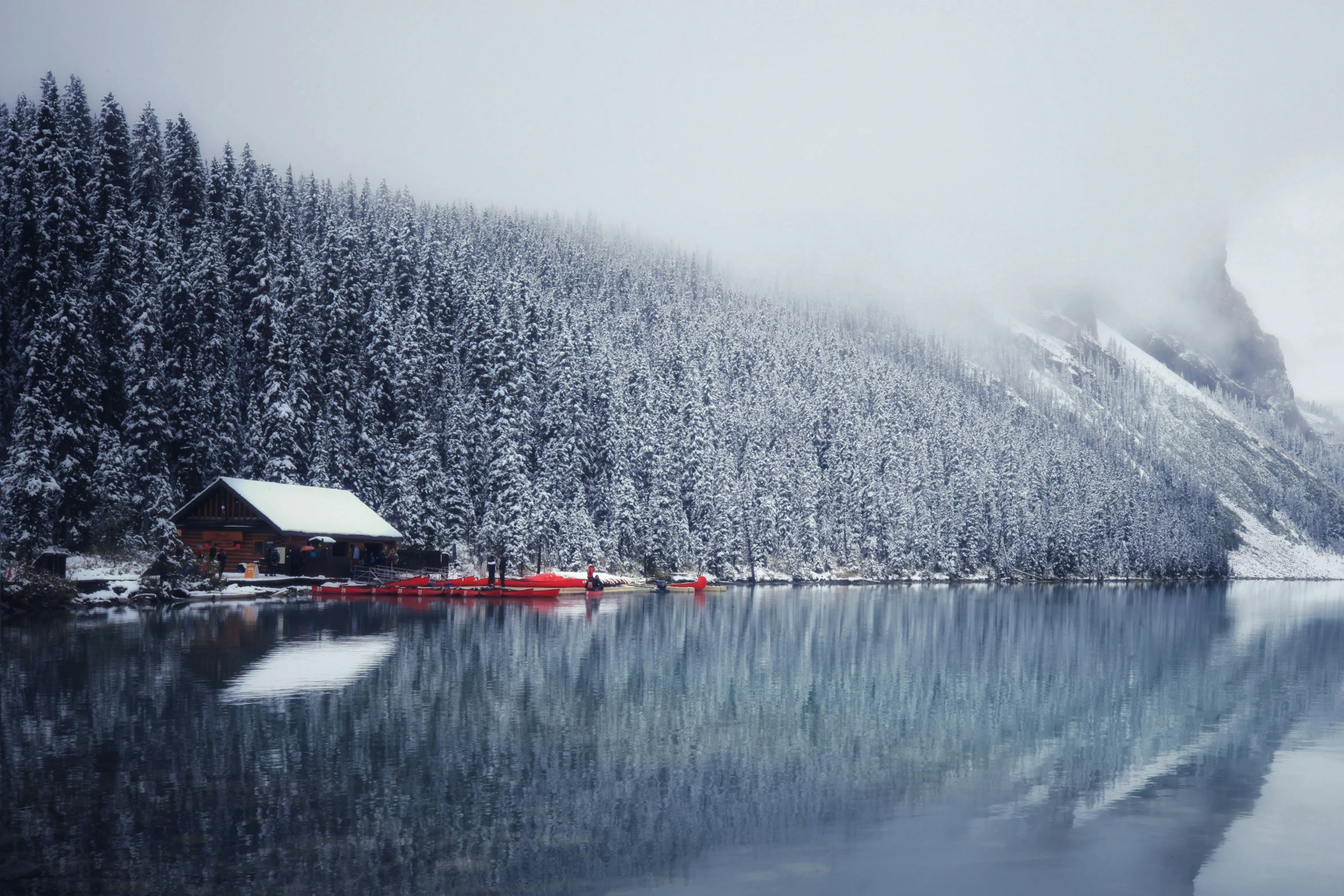 the boat is on the lake in front of the mountain