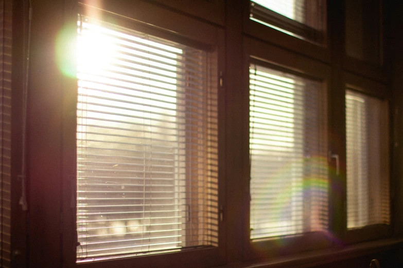 a bright window has blinds on the side and the sun shining