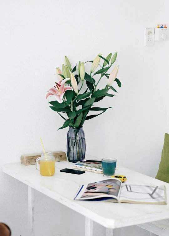 there is a vase of flowers and a glass on a table