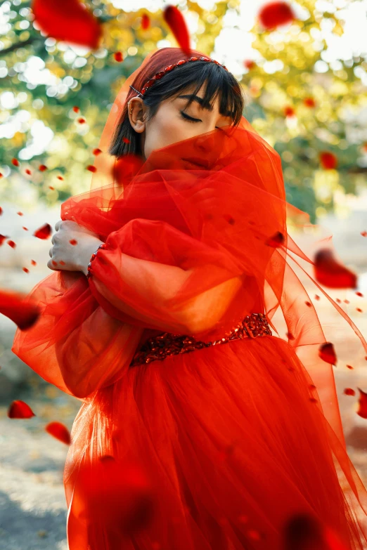 the woman is wearing an orange dress and posing for the camera