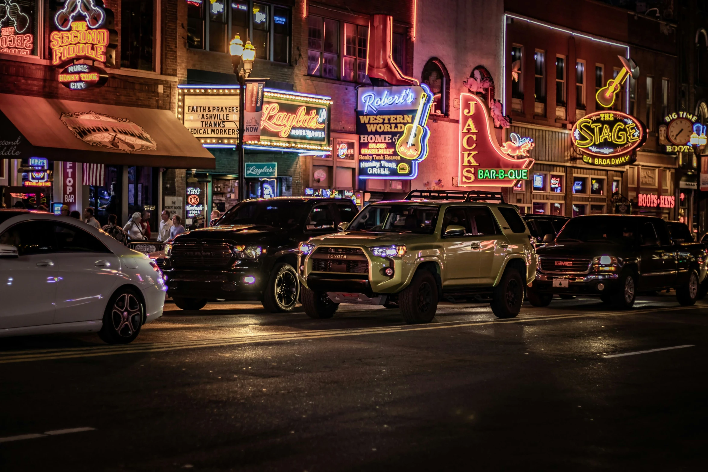 cars are parked on the street in the city at night