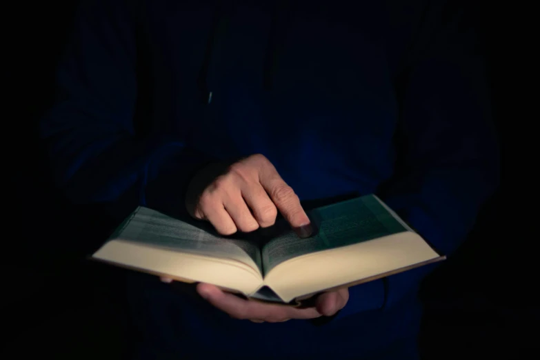a person in the dark reading a book