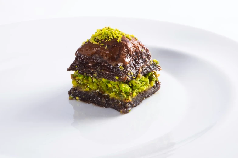 a brownie with green sprinkles on a white plate