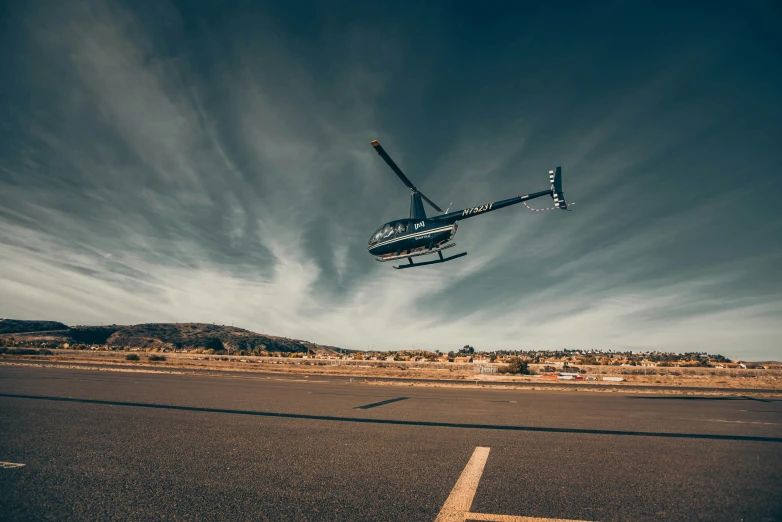 a small plane flying over a runway near a mountain range