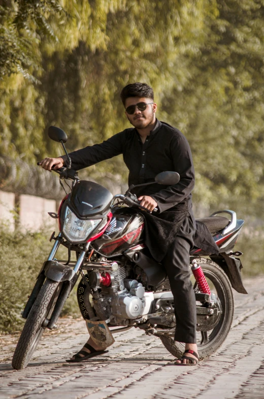 a man sits on the back of a parked motorcycle